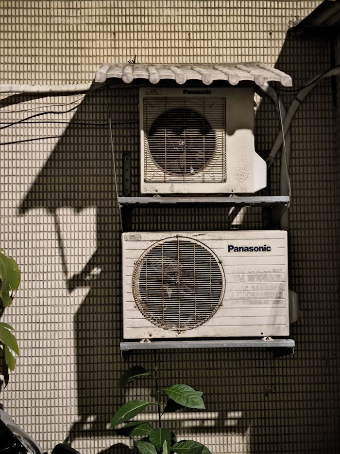 portfolio-04 Close-up of two air conditioning units on a building facade in sunlight.